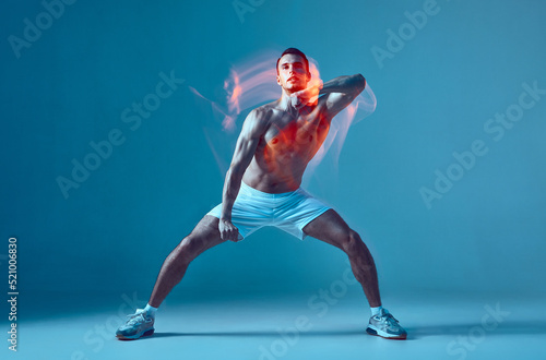 Dancing athletic sexy young male with naked muscular torso performs contemporary energetic dance. Motion blur