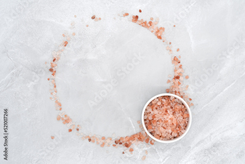 Himalayan pink salt in bowl on stone texture background photo