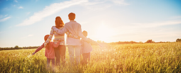 Happy family in the nature together on the evening sunset