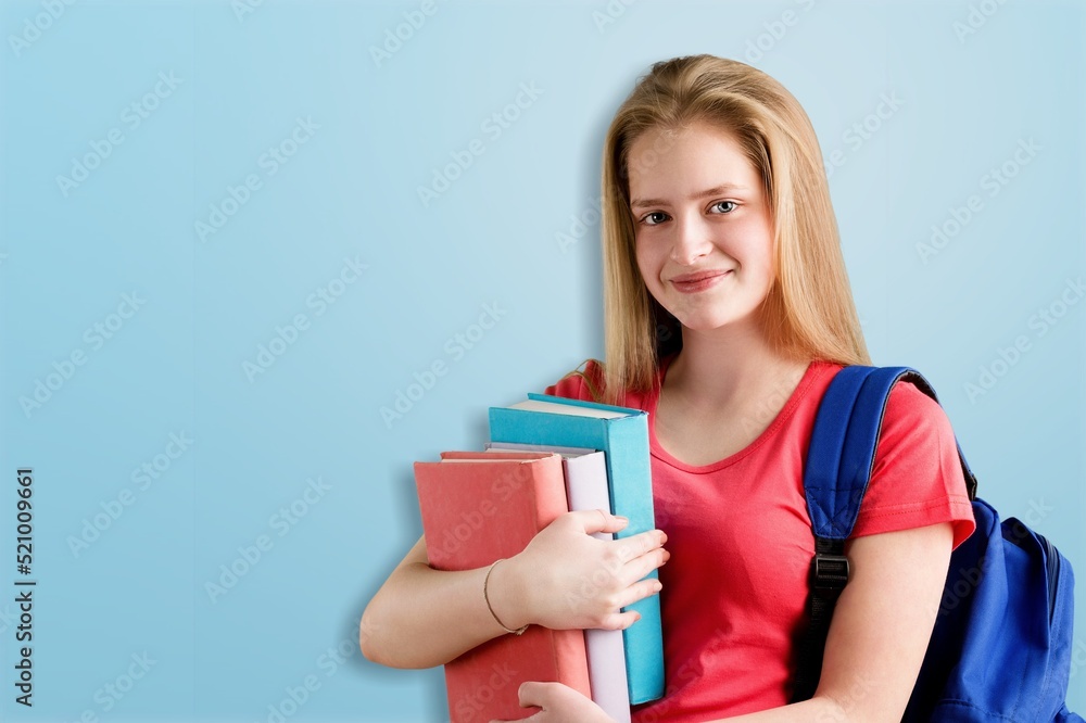 Happy young woman wearing a backpack while carrying books and notebooks go to college Happy young woman wearing a backpack while carrying books and notebooks go to college