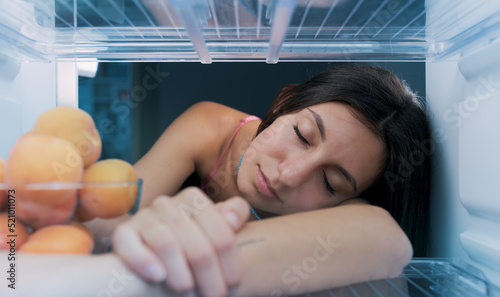 Foto Woman cooling herself in the fridge