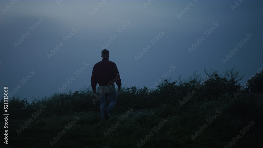 Casual man walking in field. Inspired guy felling freedom in foggy landscape