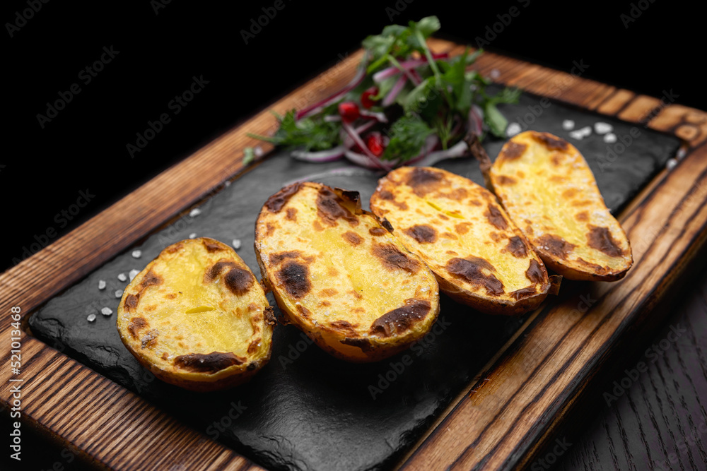 Baked potatoes on a wooden board with salt. selective focus