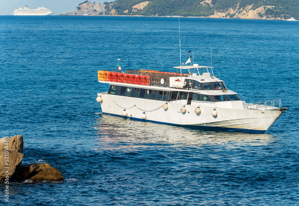 Empty ferry to the Cinque Terre and a cruise ship in front of the ancient village of Tellaro, Mediterranean sea, Gulf of La Spezia, Liguria, Italy, Southern Europe. On background the Palmaria island.