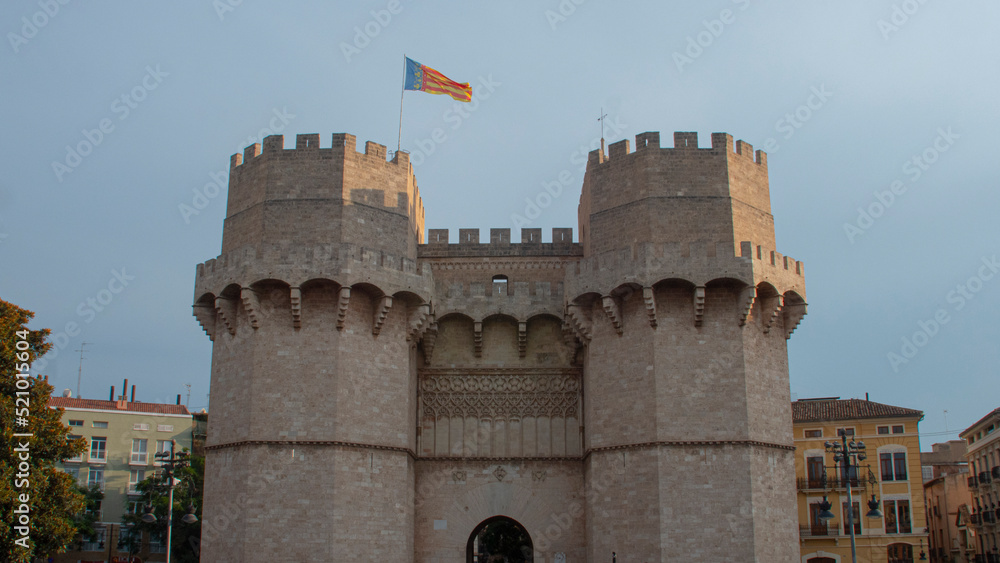 Picturesque medieval towers in the city of Valencia with flag