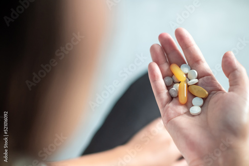 Women hands holding pills diffrent shape and colors, top view,Healthcare and medical concept.