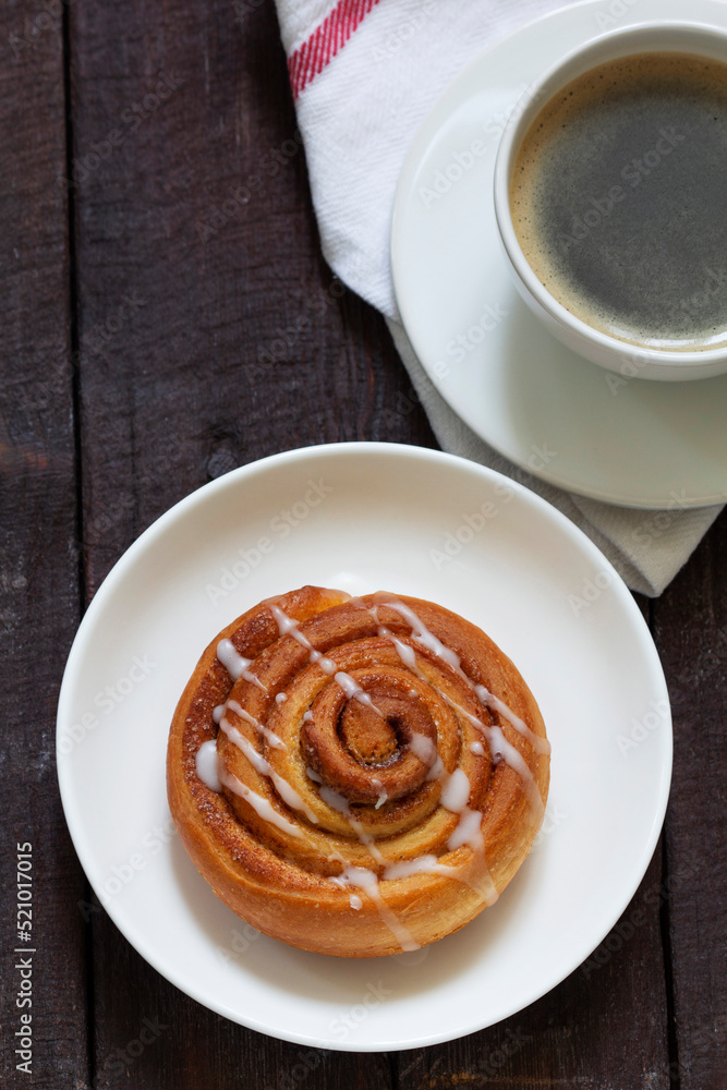 Cinnamon buns with icing served with coffee. Rustic style.