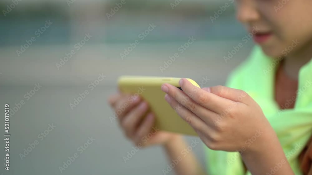Hands using app on mobile phone over sunset. Close up young attractive boy using phone on street sunlight sunset Hands using app on mobile phone over sunset. Close up young attractive boy using phone on street sunlight sunset