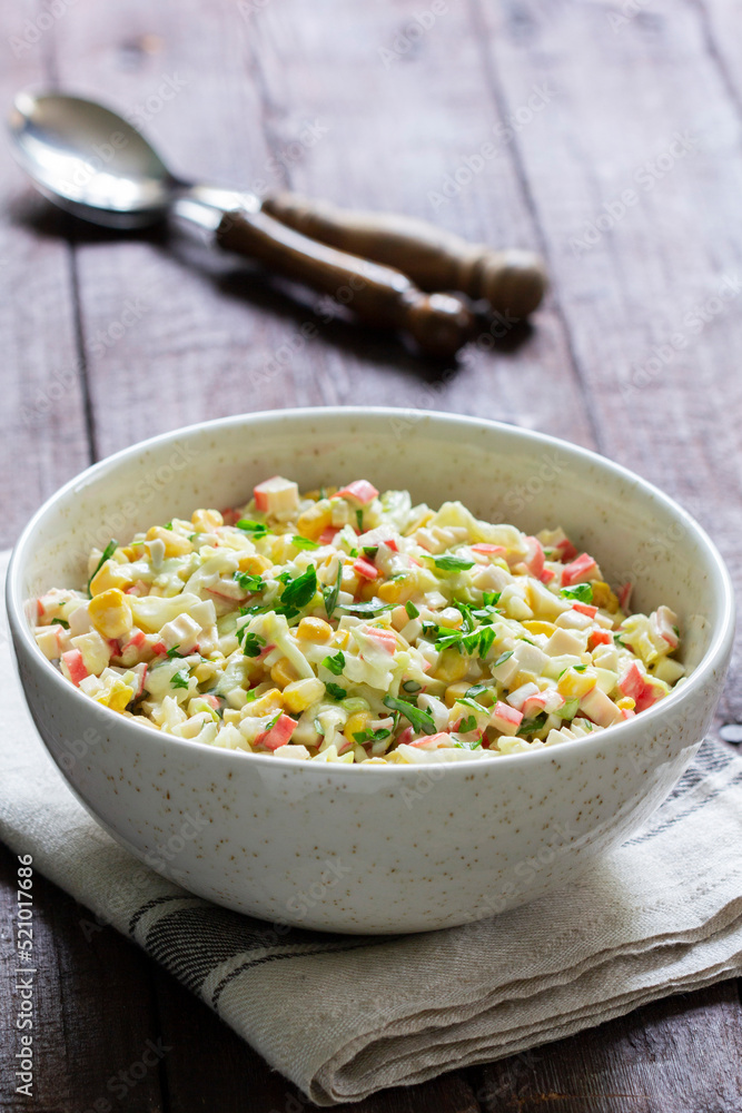 Vegetable salad with crab sticks, dressed with mayonnaise.