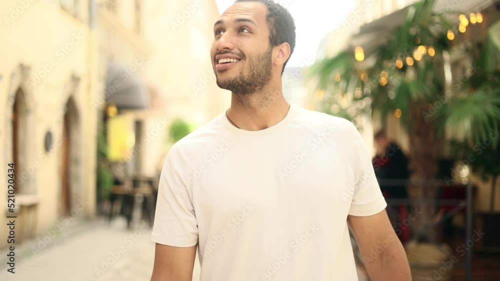 Close up of attractive young African american man walking down the city street and looking ahead. Handsome guy outside. Close up of attractive young African american man walking down the city street and looking ahead. Handsome guy outside.
