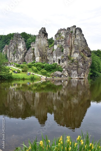 Famous rocks "Externsteine" reflecting in a pond in Westfalia, Germany