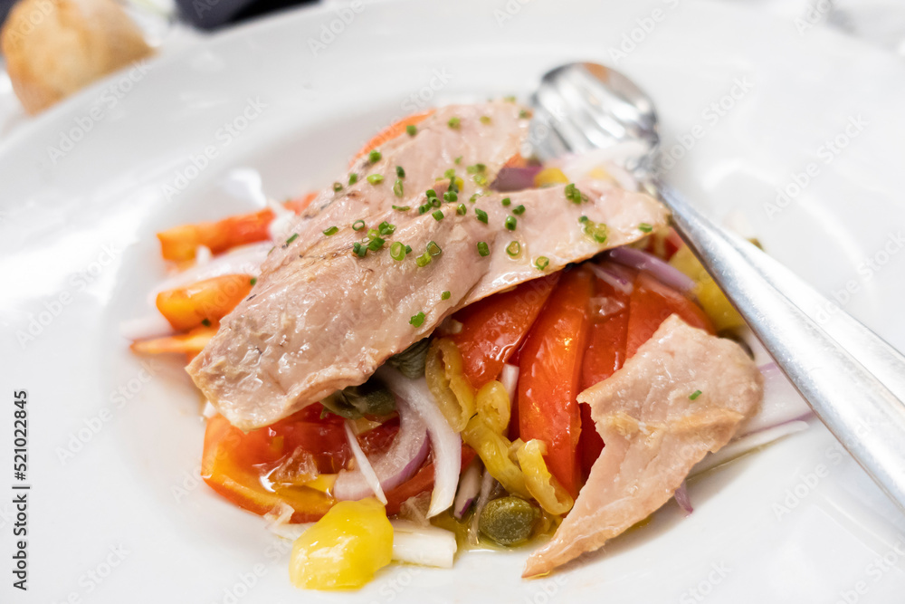 refreshing tuna belly tuna salad with peppers and onion in a white dish