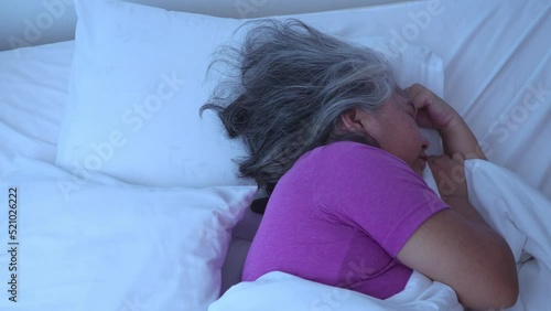 Senior woman with gray hair in bed feel depressed or suffering from strong headache migraine and high blood pressure, insomniac trying to sleep disturbed toss and turn in bedroom