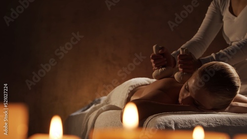 Young, healthy and beautiful woman gets massage therapy in the spa salon. Healthy lifestyle and body care concept.