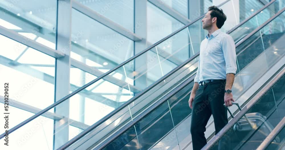 A traveling professional business man at the airport, holding a suitcase and taking a trip to a new city. A corporate executive coming down an escalator with luggage in hand on his way to a new town. A traveling professional business man at the airport, holding a suitcase and taking a trip to a new city. A corporate executive coming down an escalator with luggage in hand on his way to a new town.