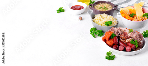 Web banner with Cocido Madrileno, traditional Spanish stew with assorted meat, vegetables, chickpea and noodles served separately on white. Mockup with copy space