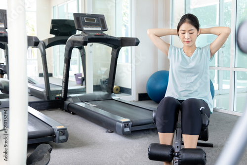 Beautiful and shapely Asian woman working out in the gym, Play exercise machine treadmill, Dumbbell, stretching, Hanging bar, Barbell, Cardio, Stretch, Woman warming up in the gym, Jump rope.