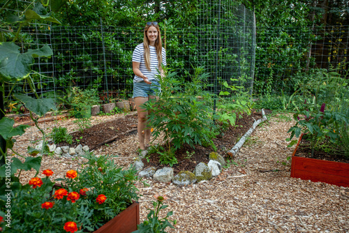 Valokuva A young woman growing Cannabis plants in Canada in a home Garden, where it's legal to grow up to 4 cannabis plants per household