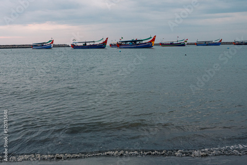 Fishing boats docked in the harbor during the sunset and blue hour