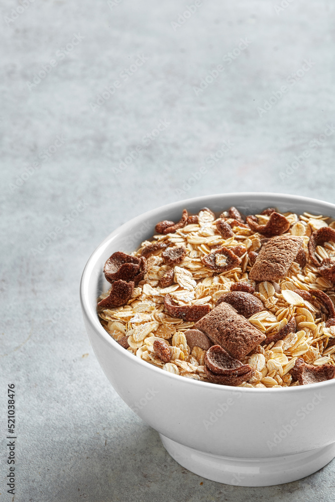 Muesli in a white bowl on a neutral background viewed from above. Copy space Muesli in a white bowl on a neutral background viewed from above. Copy space