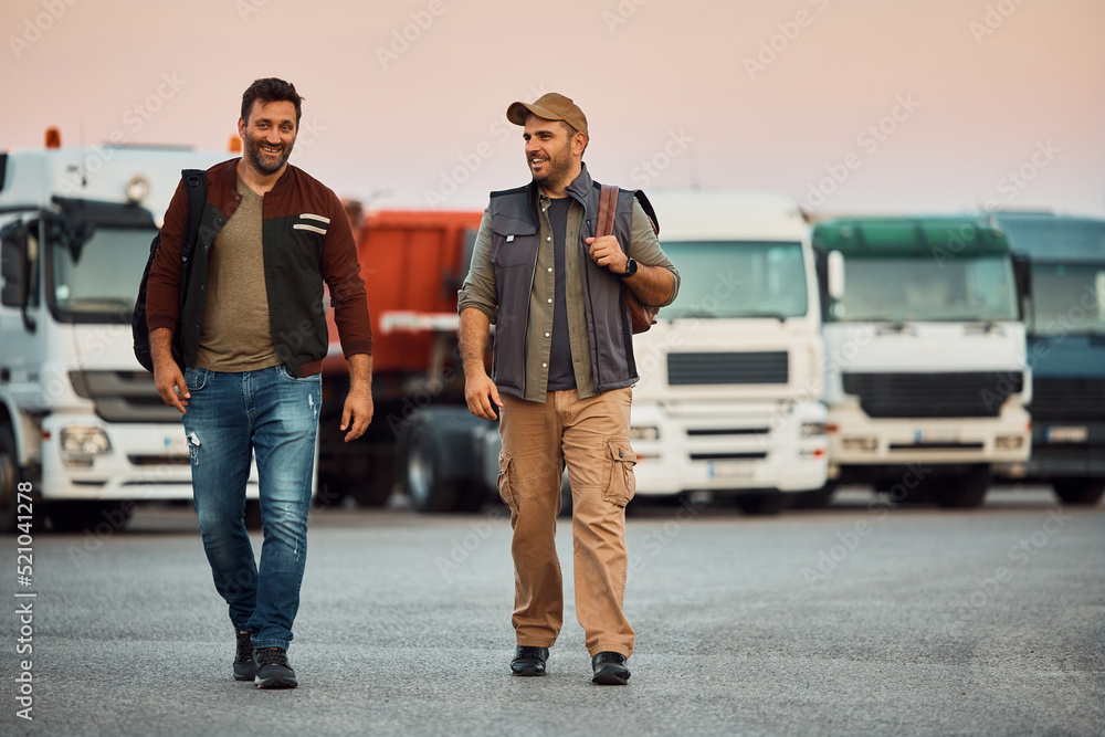 Happy truck drivers talk while walking on parking lot. Stock Photo ...