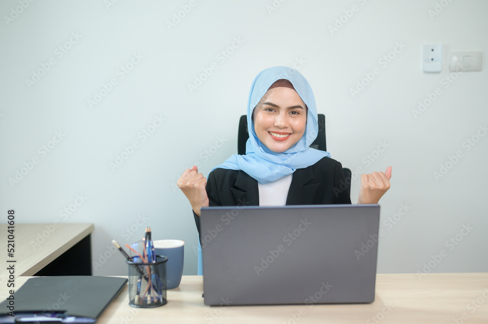 Young muslim business woman working on laptop with documents in modern office Young muslim business woman working on laptop with documents in modern office