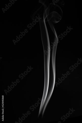 A single white smoke burn from incense, shot in studio with dark black background, for design and religion concept