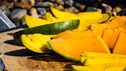 Bild auf Leinwand Image of mango and melon slices on the beach