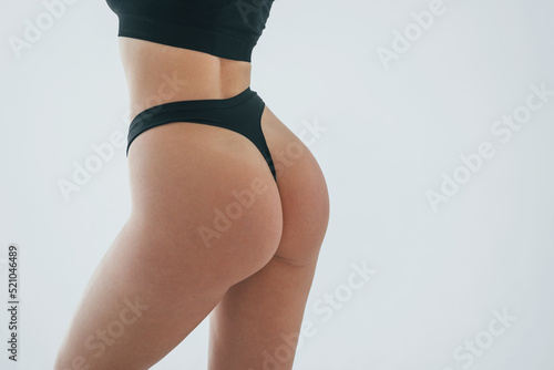 Close up view. Woman in underwear with slim body type is posing in the studio