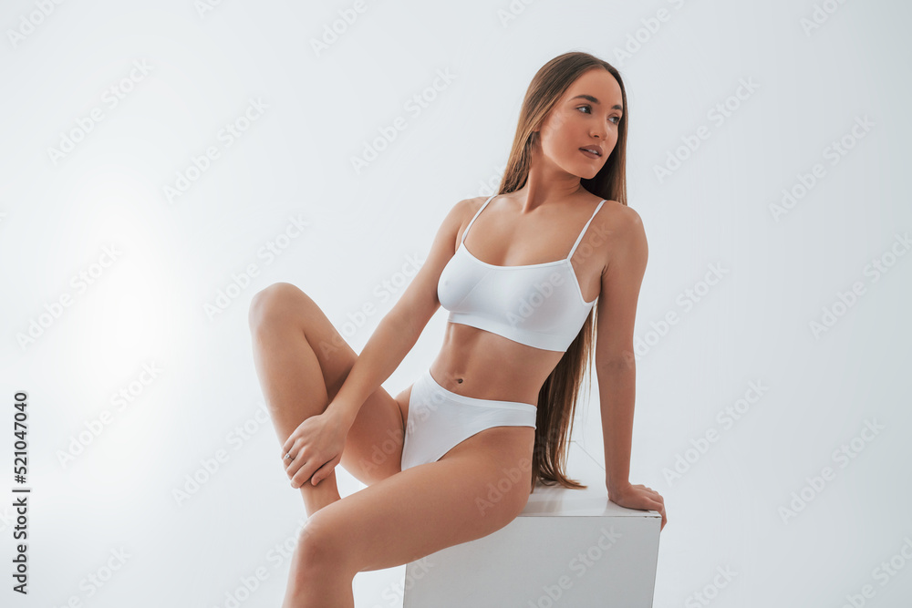Foto de Front view. Woman in underwear with slim body type is posing in the  studio do Stock