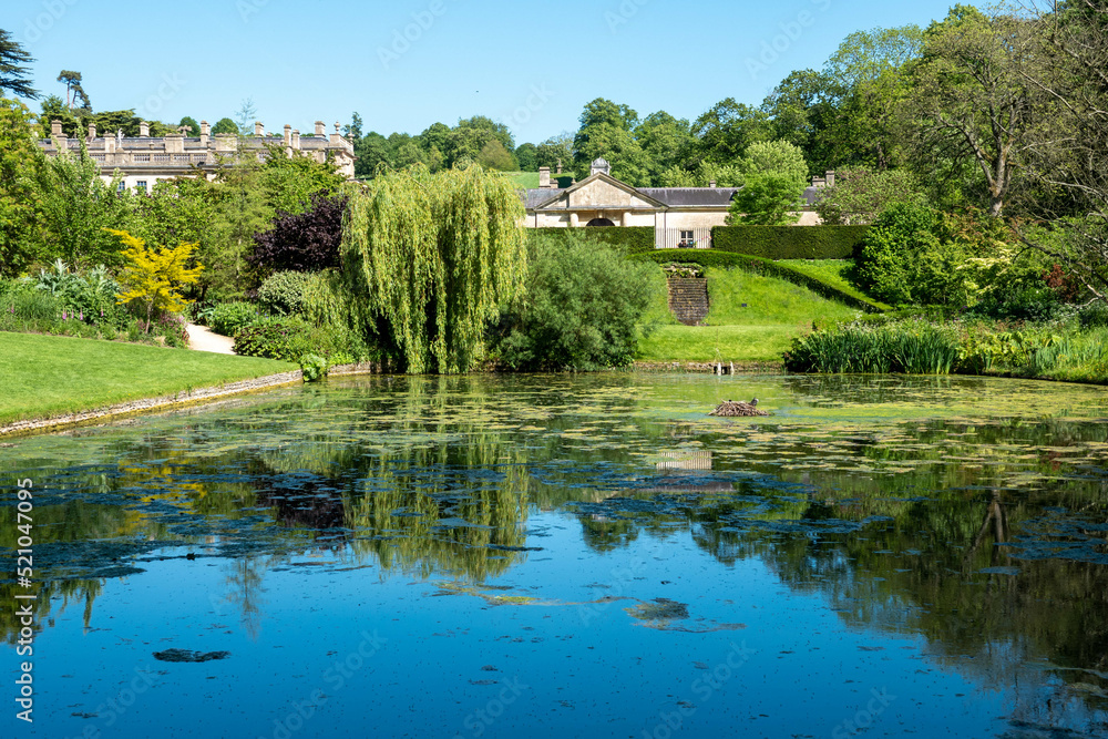 view of  the roof of Dyrham House across an ornamental pond