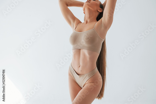 Full lenght view. Woman in underwear with slim body type is posing in the studio photo
