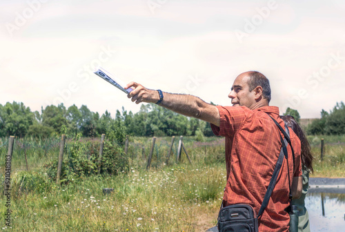 A man pointing with his arm to the horizon during a walk to the countryside. Nature in the background . Copy space.
