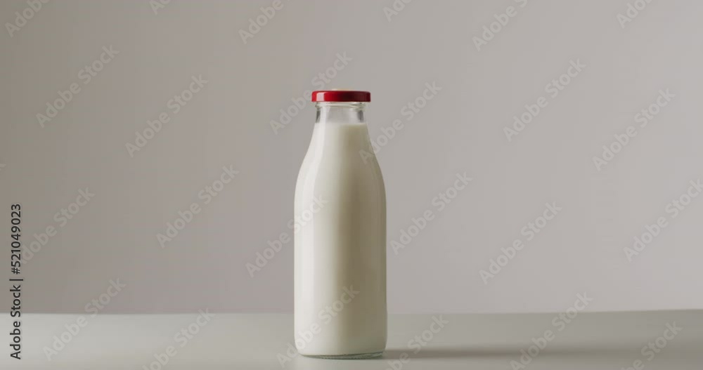 Video of glass bottles of milk on white background Video of glass bottles of milk on white background