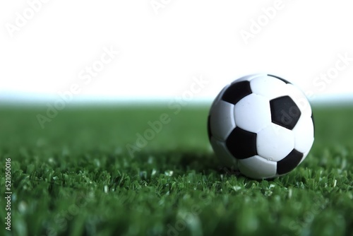 Selective focus image of football, soccer ball on green soccer field isolated on white background © izzuan