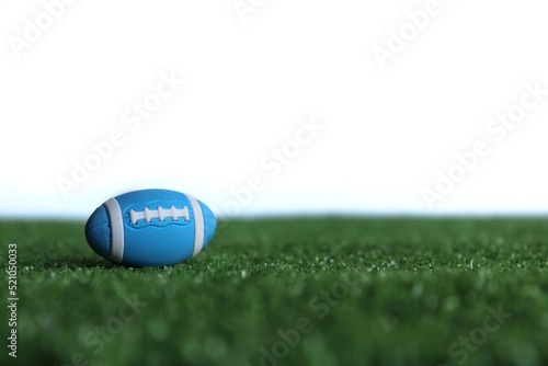 Selective focus image of rugby ball on rugby pitch grass isolated on white background