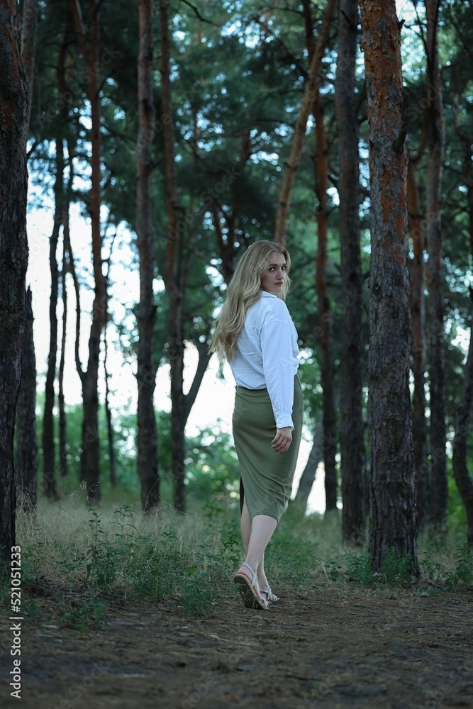 Beautiful girl walks in the park and looks at the camera. High quality photo Beautiful girl walks in the park and looks at the camera. High quality photo
