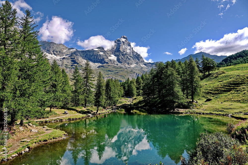 Summer alpine landscape with the Matterhorn (Cervino) reflected on the Blue Lake (Lago Blu) near Breuil-Cervinia. Aosta Valley, Italy - August 2022