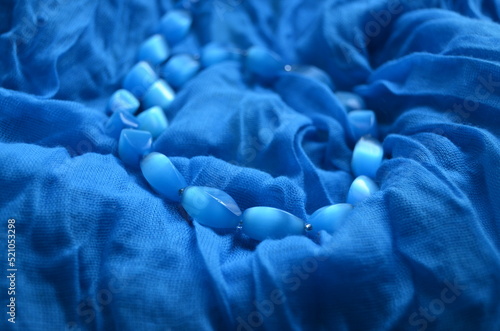 Blue beads from a natural stone on a female scarf.