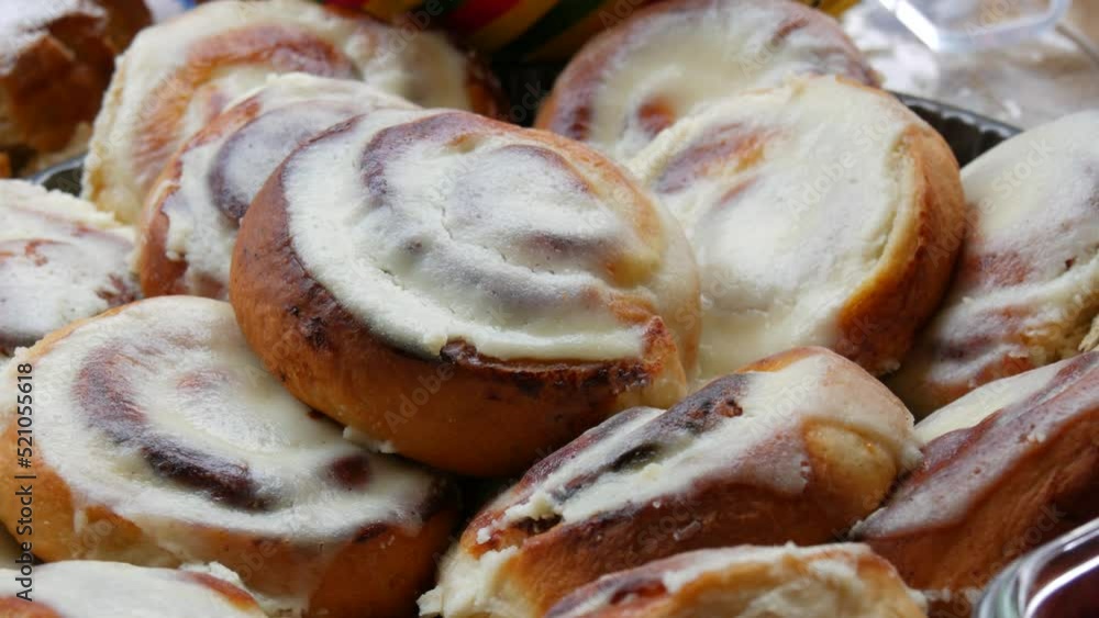 Round homemade baked cinnabons with white icing on top, close up view. Homemade buns. Round homemade baked cinnabons with white icing on top, close up view. Homemade buns.