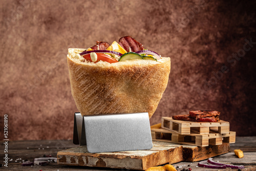 Kebab, pita, gyros, shaurma, wrap sandwich stuffed with sausages from minced meat with grilled meat, vegetables and sauce on dark background. banner, menu, recipe place for text, top view