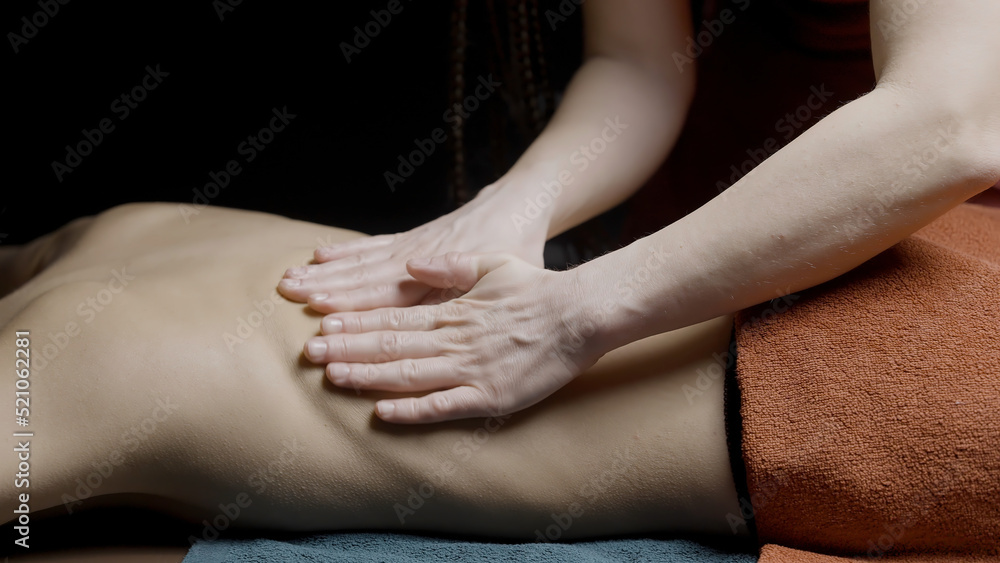 Close up of professional masseuse massaging back and shoulders of a female client. Action. concept of spa relaxing wellness.