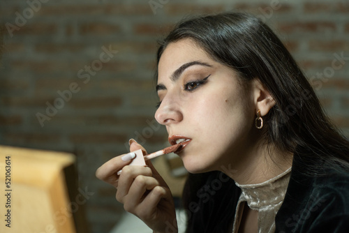Young woman doing her make-up for a party