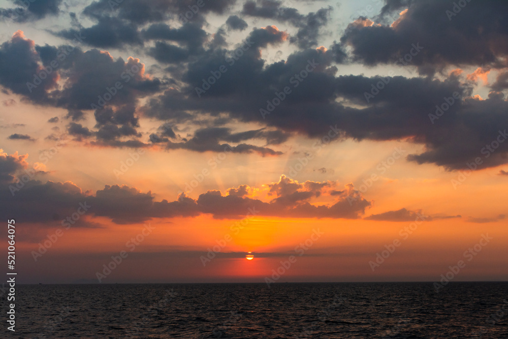 Beautiful  sea sunset in the Gulf of Thailand.  The setting sun has set behind a cloud.