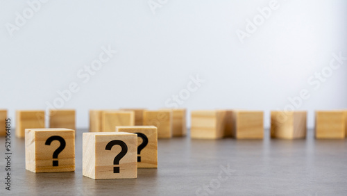front view on many wood cubes with question marks. many question arising concept