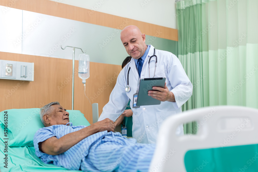 Doctor Visiting man Patient On Ward. Hospitalized man lying in bed while doctor checking his. physician examining male patient in hospital room. Doctor Visiting man Patient On Ward. Hospitalized man lying in bed while doctor checking his. physician examining male patient in hospital room.