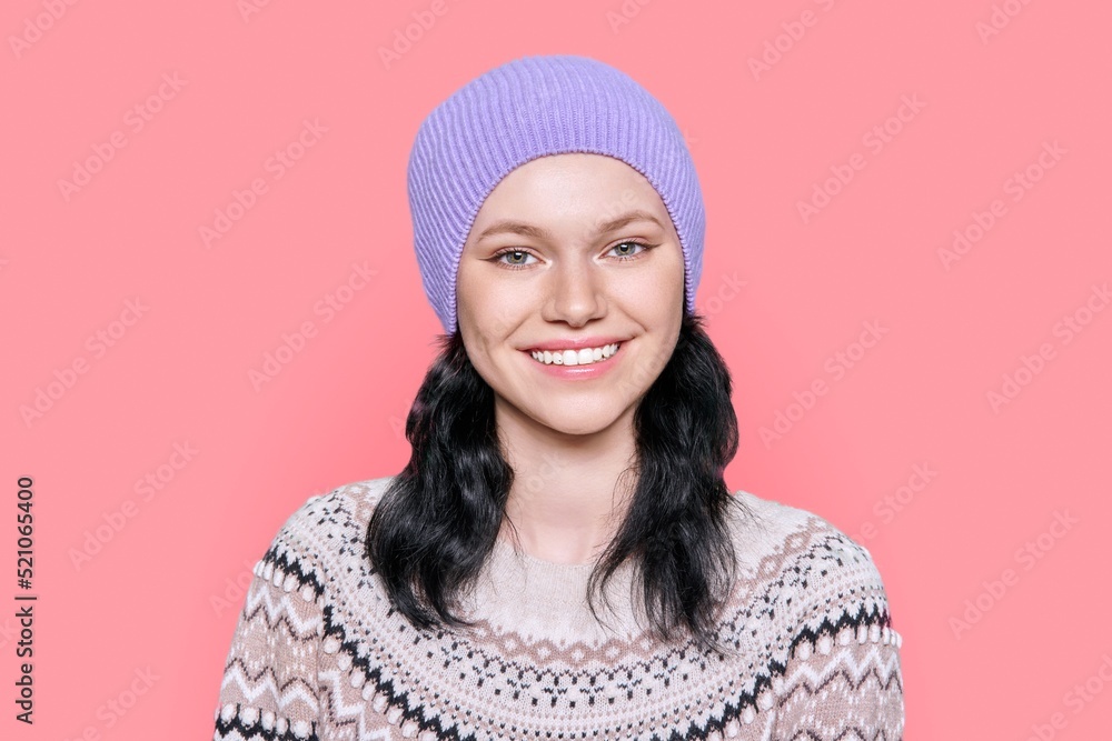 Portrait of young woman in hat in sweater on pink background Portrait of young woman in hat in sweater on pink background
