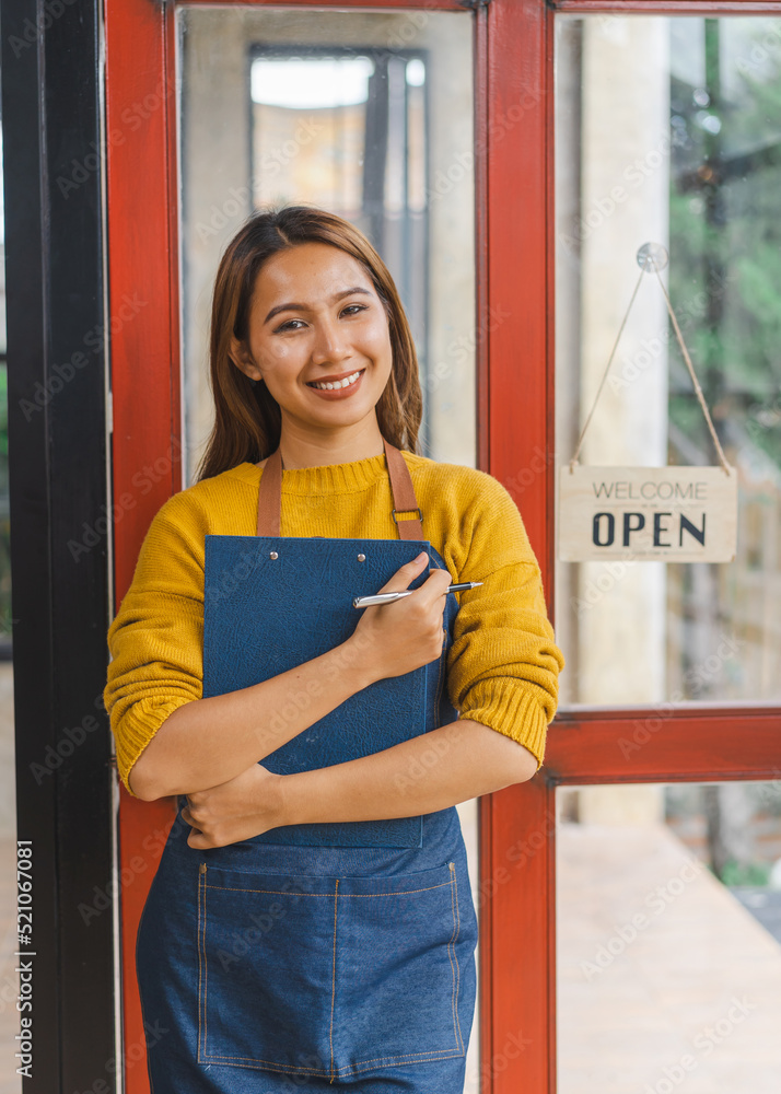 Young Asian freelancer coffee shop owner standing with open sign, standing front of the door.