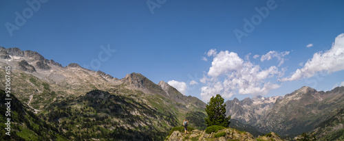 Fototapeta Naklejka Na Ścianę i Meble -  Hiker woman on top of a mountain watching mountainous landscape of Pyrenees