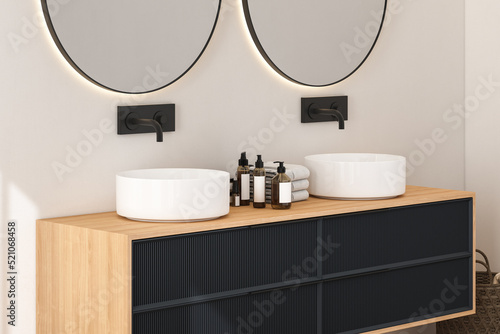 Close up of modern bathroom cabinet with white wall  double sink standing on wooden countertop and two round mirrors. 3d rendering